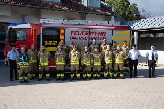 Personen vor Feuerwehrauto