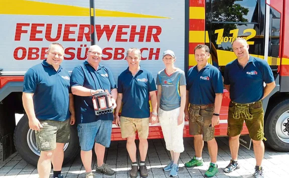 Personen vor Feuerwehrauto mit Lampe
