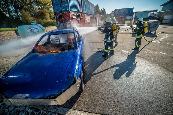 Personen bei Atemschutzübung beim Löschen eines Autos
