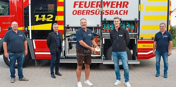 Personen vor Feuerwehrauto