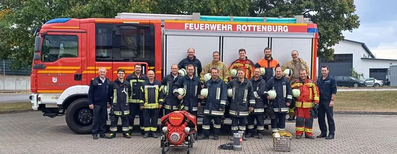 Gruppe von Personen vor Feuerwehrauto